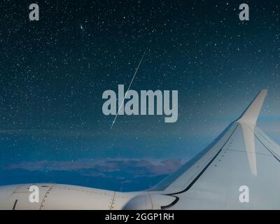 Blick vom Flugzeugfenster in der Nacht unter einem Sternenhimmel Stockfoto