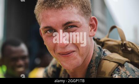 U.S. Marine Corps Lance CPL. Derek Mensch, gebürtig aus Syracuse, N.Y. und ein Randalier mit 1. Bataillon, 6. Marine Regiment, 2d Marine Division, hilft bei der Auslagerung von Boxen für die Umverteilung in Port of Jeremie, Haiti, 31. August 2021. „Es war besser, als ich erwartet hatte, mit den Haitianern zusammenzuarbeiten, war eine erstaunliche Erfahrung“, sagte Mensch. Die Marineinfanteristen und Seeleute an Bord der USS Arlington (LPD 24) haben sich für eine Mission zur humanitären Hilfe und Katastrophenhilfe der Joint Task Force Haiti eingesetzt. „Es war bemerkenswert, dort zu sein und Tausenden von Menschen helfen zu können. Lächelnd Stockfoto