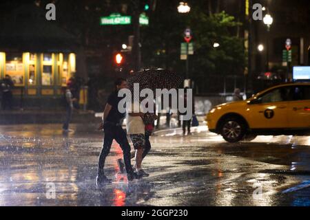 New York, USA. September 2021. Die Menschen laufen im Regen, der durch den Unwetter-Ida verursacht wird, auf einer Straße in New York, USA, 2. September 2021. Kathy Hochul, Gouverneurin des Bundesstaates New York, erklärte am frühen Donnerstag ihren ersten Ausnahmezustand, da die Überreste des Wirbelstromes Ida sintflutartige Regenfälle und schwere Überschwemmungen in die Nordostregion der USA brachten. Quelle: Wang Ying/Xinhua/Alamy Live News Stockfoto