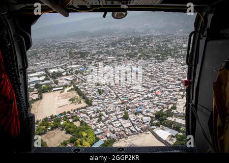 210828-N-PC065-1250 HAITI (AUG 28, 2021) eine städtische haitianische Landschaft wird vom Hubschrauber MH-60S Sea Hawk beobachtet, der an die „Schneemänner“ des Helicopter Sea Combat Squadron (HSC) 28, 28. August 2021, angeschlossen ist. HSC-28 wird auf dem amphibischen Transportschiff USS Arlington (LPD 24) der San Antonio-Klasse an Bord genommen, das beim U.S. Naval Forces Southern Command/U.S. eingesetzt wird 4. Flotte zur Unterstützung der humanitären Hilfe und der Katastrophenhilfe (HADR) in Haiti nach einem Erdbeben der Stärke 7.2 am 14. August 2021. (USA Navy Foto von Mass Communication Specialist 2nd Class John Bellino/veröffentlicht) Stockfoto