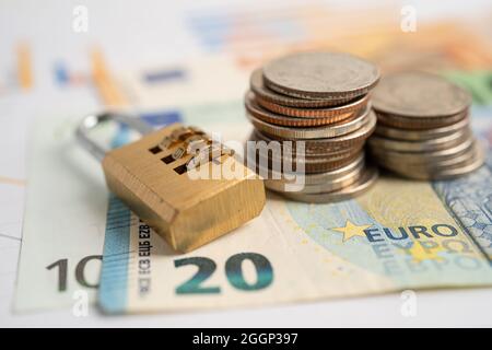 Goldene Sicherheit digitalen Passwort-Schlüssel und Münzen mit Euro-Banknoten auf Grafik, Handel Finanzierungskonzept. Stockfoto