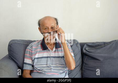 Kahlköpfiger älterer Mann aus Asien mit schwarzer Brille Stockfoto