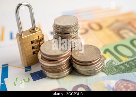 Goldene Sicherheit digitalen Passwort-Schlüssel und Münzen mit Euro-Banknoten auf Grafik, Handel Finanzierungskonzept. Stockfoto
