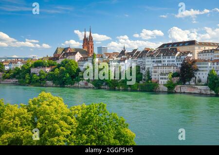 Blick auf das Basler Münster inmitten der Basler Altsatdt mit dem türkischen Rhein Fluss im Vordergrund Stockfoto