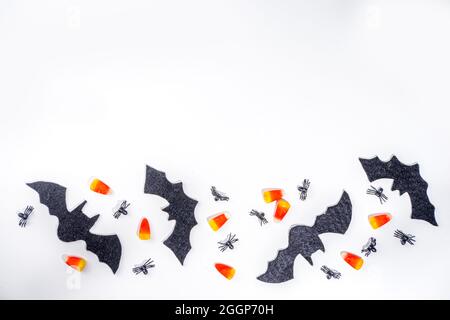 Halloween Rahmen Hintergrund. Fledermaus- und Spinnendekorationen mit traditionellem Trick o Treat Candy Corn auf weißem Hintergrund. Halloween Grußkarte. Flat la Stockfoto