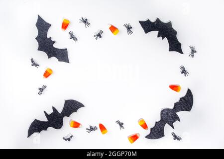 Halloween Rahmen Hintergrund. Fledermaus- und Spinnendekorationen mit traditionellem Trick o Treat Candy Corn auf weißem Hintergrund. Halloween Grußkarte. Flat la Stockfoto