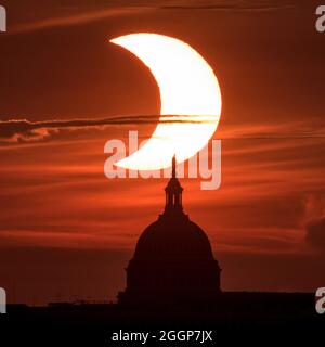 Am Donnerstag, dem 10. Juni 2021, wird ein teilweiser „Feuerring“ der Sonnenfinsternis gesehen, wenn die Sonne hinter der Freiheitsstatue auf dem Kapitolgebäude der Vereinigten Staaten aufgeht. Stockfoto