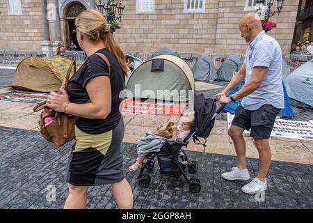 Barcelona, Spanien. September 2021. Touristen werden vor dem Zeltlager vorbeikommen sehen, das während eines Streiks auf der Plaza de Sant Jaume eingerichtet wurde.Zweiter Tag des Hungerstreiks auf der Plaza Sant Jaume von Geschäftsleuten und Ausgehern nach dem TSJC (Supreme Court of Justice of Catalonia) Bestätigte die Argumente der Generalitat de Catalunya, das Nachtleben wegen der sogenannten fünften Welle von Covid19 geschlossen zu halten. Kredit: SOPA Images Limited/Alamy Live Nachrichten Stockfoto