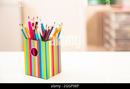 Bleistifte in einem Halter auf dem Schreibtisch des Schülers, verwischen den Innenhintergrund des Zimmers. Bildung, zurück in die Schule, Kinder Kreativität Konzept. Platz kopieren, Vorlage Stockfoto