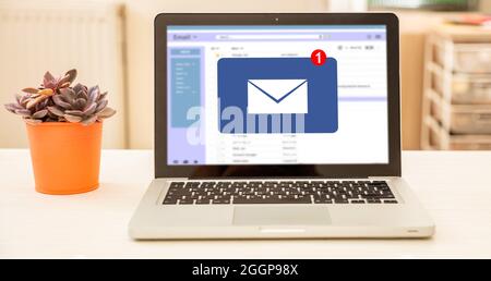 E-Mail-Posteingang auf dem Laptop-Bildschirm des Computers auf einem weißen Schreibtisch, verwischen Sie den Hintergrund im Innenraum. Stockfoto