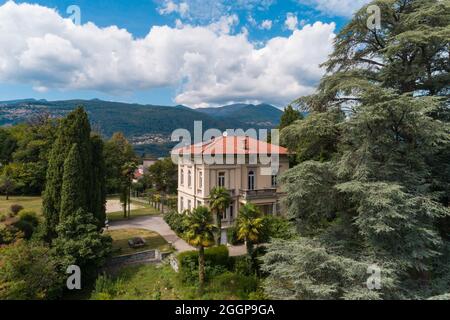 Große und alte Villa mit großem Garten um sie an einem sonnigen Sommertag Stockfoto