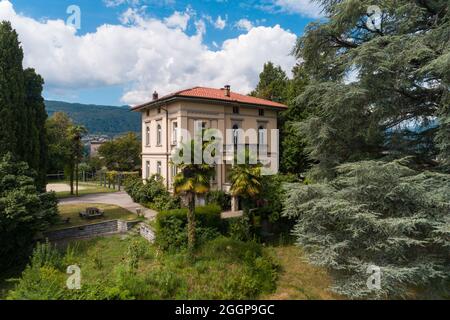 Große und alte Villa mit großem Garten um sie an einem sonnigen Sommertag Stockfoto