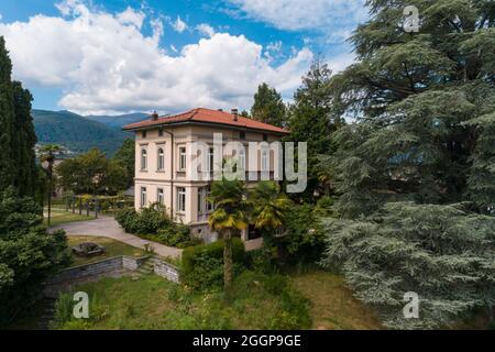 Große und alte Villa mit großem Garten um sie an einem sonnigen Sommertag Stockfoto