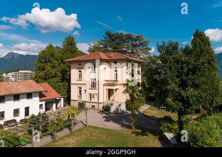 Große und alte Villa mit großem Garten um sie an einem sonnigen Sommertag Stockfoto