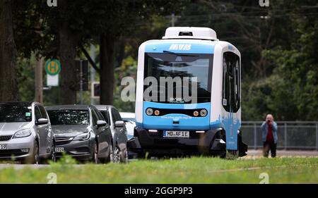 Magdeburg, Deutschland. September 2021. Der französische Minibus EZ10, ein autonom fahrender Shuttle-Bus, fährt durch die Altstadt von Magdeburg. Mit bis zu 15 Stundenkilometern fährt ab Freitag das intelligente Elektro-Shuttle „Elbi“ durch Magdeburg. Bis Ende des Jahres pendeln die sechs Sitze umfassenden Minibusse auf einer vorprogrammierten Strecke zwischen der Seumstraße in der Altstadt und dem Stadtpark. Quelle: Ronny Hartmann/dpa/Alamy Live News Stockfoto