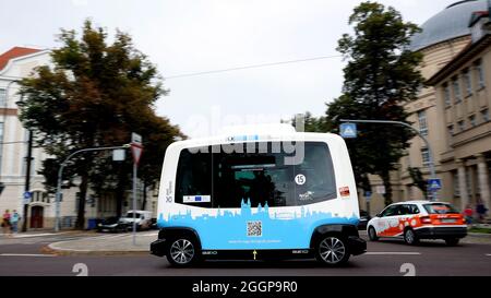 Magdeburg, Deutschland. September 2021. Der französische Minibus EZ10, ein autonom fahrender Shuttle-Bus, fährt durch die Altstadt von Magdeburg. Mit bis zu 15 Stundenkilometern fährt ab Freitag das intelligente Elektro-Shuttle „Elbi“ durch Magdeburg. Bis Ende des Jahres pendeln die sechs Sitze umfassenden Minibusse auf einer vorprogrammierten Strecke zwischen der Seumstraße in der Altstadt und dem Stadtpark. Quelle: Ronny Hartmann/dpa/Alamy Live News Stockfoto