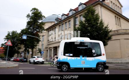 Magdeburg, Deutschland. September 2021. Der französische Minibus EZ10, ein autonom fahrender Shuttle-Bus, fährt durch die Altstadt von Magdeburg. Mit bis zu 15 Stundenkilometern fährt ab Freitag das intelligente Elektro-Shuttle „Elbi“ durch Magdeburg. Bis Ende des Jahres pendeln die sechs Sitze umfassenden Minibusse auf einer vorprogrammierten Strecke zwischen der Seumstraße in der Altstadt und dem Stadtpark. Quelle: Ronny Hartmann/dpa/Alamy Live News Stockfoto