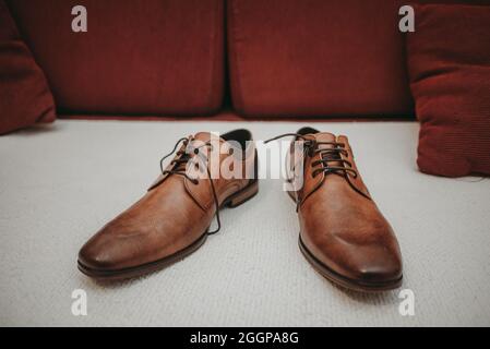 Braune Hochzeitsschuhe aus Leder auf dem Sofa Stockfoto