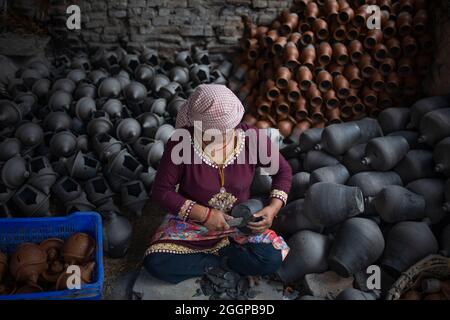 (210902) -- BHAKTAPUR, 2. September 2021 (Xinhua) -- Eine Kunsthandwerkerin arbeitet am 1. September 2021 an einer Töpferei auf einem Töpferplatz in Bhaktapur, Nepal. Bhaktapur ist bekannt für seine jahrhundertealte Töpferei, die über Generationen weitergegeben wurde. Die in Bhaktapur hergestellte Keramik wird aufgrund der Verwendung von schwarzem Ton, der nur an einem Ort gefunden werden kann und nur einmal im Jahr von den Bhaktapur-Ureinwohnern gegraben werden kann, als überlegen angesehen. (Xinhua/Sulav Shrestha) Stockfoto