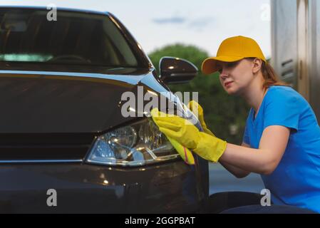 Frauen in Uniform Polieren Auto mit Teppich. Autowaschservice. Stockfoto