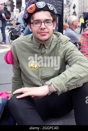 Ein Protestor, der mehrere Aufkleber für die Extinction Rebellion trägt, als die Extinction Rebellions sich während ihres Protestes für eine Massenfreitagsaktion am elften Tag ihrer Impossible Rebellion-Proteste in London, Großbritannien, am 2. September 2021 außerhalb der Bank of England aufmachen. Demonstranten, die während der Unmöglichen Rebellion verhaftet wurden, wurden ermutigt, den ganzen Tag über ihre Geschichten zu erzählen. Stockfoto