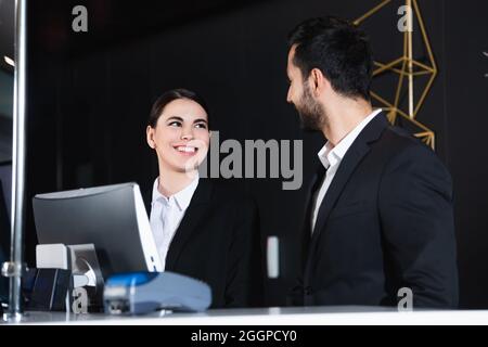 Zufriedene Verwalter, die sich an der Rezeption anguckt Stockfoto