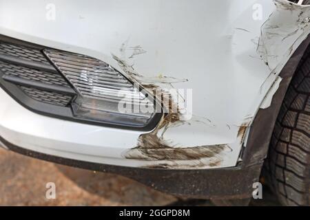 Kleiner Unfallschaden am vorderen Stoßfänger des Weißen Autos Stockfoto