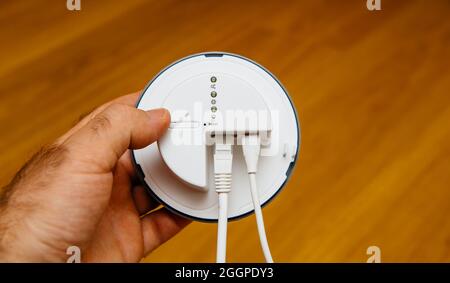 POV männliche Hand mit neuem IKEA Tradfri Gateway Stockfoto