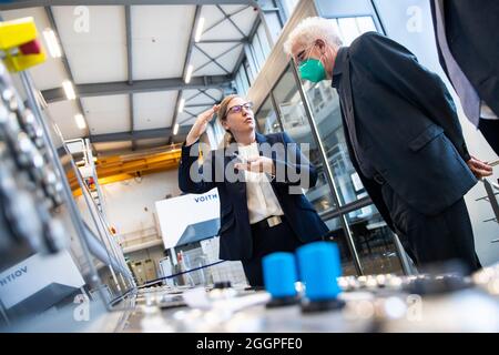 02. September 2021, Baden-Württemberg, Heidenheim: Franziska Ferrer (l.) erklärt dem baden-württembergischen Ministerpräsidenten Winfried Kretschmann (Bündnis 90/die Grünen) während des Besuchs bei Voith eine Maschine. Foto: Tom Weller/dpa Stockfoto