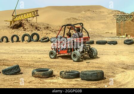 Yazd, Wüste, Iran, 20. Februar 2021: Die erste scharfe Kurve auf der Autobahn, sitzt ein kleiner Junge hinter dem Steuer eines Quad-Bikes mit seinem Vater und los Stockfoto