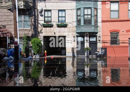 Ein Mann säubert von den Straßenüberflutungen, die durch den Hurrikaregen Ida in Hoboken, New Jersey, USA, verursacht wurden. Stockfoto