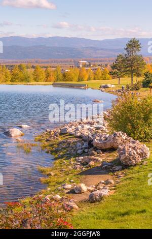 Schöne Herbstlandschaft Blick auf den See, Pinien, Holz-Chalets und Berge Sonnenuntergang Hintergrund in der Nähe von Bansko, Bulgarien Stockfoto