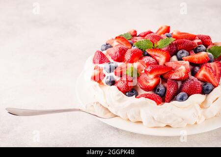 Köstlicher Pavlova-Kuchen mit frischer Erdbeere und Heidelbeere, selektiver Konzentration Stockfoto