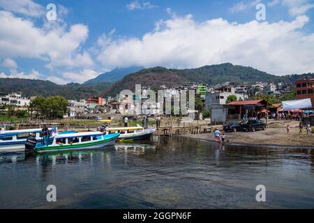 Santiago Atitlan, Guatemala - 20. März 2018: Sonniger Steg an der Küste des Atitlan-Sees mit Blick auf farbenfrohe Häuser in Santiago Atitlan, Guatemala Stockfoto