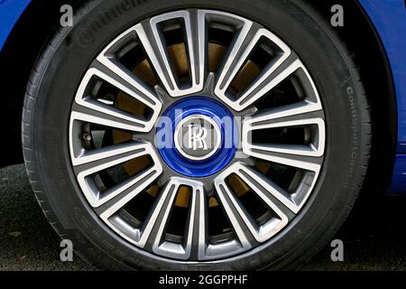 London, England - August 2021: Nahaufnahme des Emblems auf der Radnabe eines blauen Luxuswagens von Rolls Royce Stockfoto