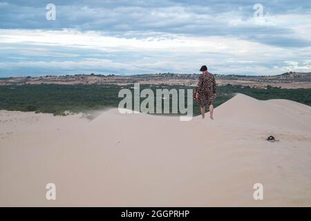 Wanderer beim Wandern in der Wüste. Junger Mann, der in weißen Sanddünen steht. Rückansicht. Fremder in der Wüste. Hochwertige Fotos Stockfoto