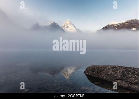 Landschaft des Mount Assiniboine in Nebel auf Magog See am Morgen im Provincial Park, Alberta, Kanada Stockfoto