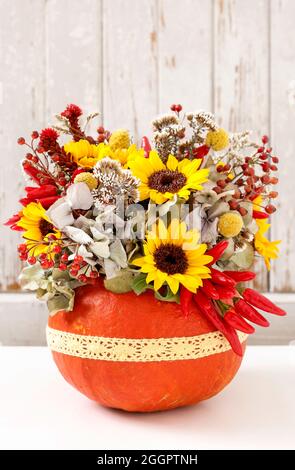Florist bei der Arbeit: Wie man eine Danksagung Mittelstück mit großen Kürbis und Blumenstrauß. Schritt für Schritt Anleitung. Stockfoto