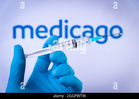 Esp. September 2021. In dieser Abbildung hält eine Hand in medizinischen Handschuhen am 2. September 2021 eine Spritze vor dem Medicago-Logo in Barcelona, Spanien. Medicago ist ein neuer vegetaler Impfstoff gegen Covid-19, der derzeit entwickelt wird. (Foto von Davide Bonaldo/Sipa USA) Quelle: SIPA USA/Alamy Live News Stockfoto