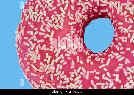 Pinker Donut mit Prise auf pastellblauem Hintergrund. Zucker, Süßigkeiten, Snack, Junk-Food-Konzept. Draufsicht. Platz für Text. Flach liegend Stockfoto