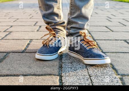 Junge Person, die Turnschuhe trägt und auf dem Bürgersteig läuft. Gehzeit Stockfoto