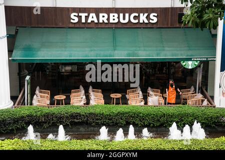 Bangkok, Thailand. September 2021. Ein Angestellter hat gesehen, wie er den Boden im Starbucks Coffee Shop gereinigt hat. Die thailändische Regierung hebt die Sperre am 01. September teilweise auf, lockerte die COVID-19-Beschränkungen wie die Wiedereröffnung von Einkaufszentren und Schönheitssalons sowie die Einspeisungen und nahm auch nach der Sperre vom 12. Juli 2021 wegen der Covid-19-Krise die interprovinziellen Reisen wieder auf. Kredit: SOPA Images Limited/Alamy Live Nachrichten Stockfoto