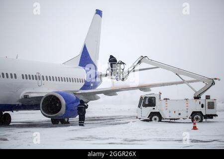 Schutz vor dem Einfrieren von Flugzeugen. Prozess der Abdeckung des Passagierflugzeugs mit Flüssigkeit gegen Einfrieren vor dem Abflug Stockfoto