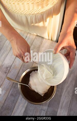 Der Prozess der Herstellung von Schokolade Glasur. Schritt für Schritt. Die Zutaten werden in einem Topf gemischt. Langsam aufwärmen, um sich aufzulösen. Stockfoto