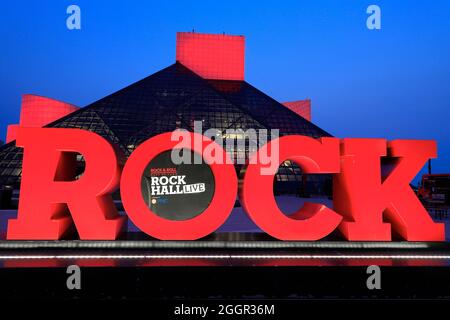 Die Nachtansicht der Rock and Roll Hall of Fame, entworfen vom Architekten I.M.Pei. Mit Long Live Rock-Schild im Vordergrund.Cleveland.Ohio.USA Stockfoto