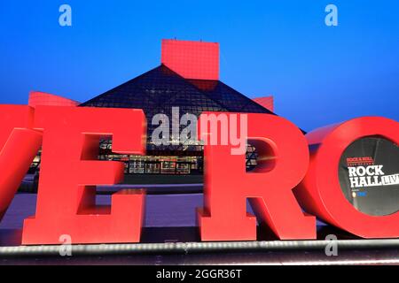 Die Nachtansicht der Rock and Roll Hall of Fame, entworfen vom Architekten I.M.Pei. Mit Long Live Rock-Schild im Vordergrund.Cleveland.Ohio.USA Stockfoto