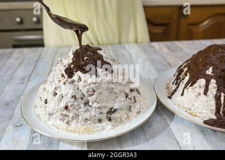 Der Prozess der Herstellung von Schokolade Glasur. Schritt für Schritt. Eine Frau gießt Glasur über hausgemachte Kuchen. Stockfoto