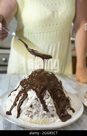 Der Prozess der Herstellung von Schokolade Glasur. Schritt für Schritt. Eine Frau gießt Glasur über hausgemachte Kuchen. Stockfoto