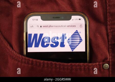 KONSKIE, POLEN - 17. August 2021: Das Logo von West Pharmaceutical Services Inc, das auf dem Mobiltelefon in der Jeanstasche versteckt ist Stockfoto