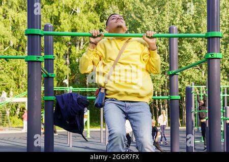 Ein Mann zieht sich auf die Straße. Straßentraining. Das Konzept eines aktiven Lebensstils. Stockfoto